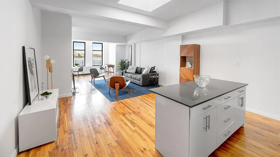 A living room with hard wood floors and white walls.