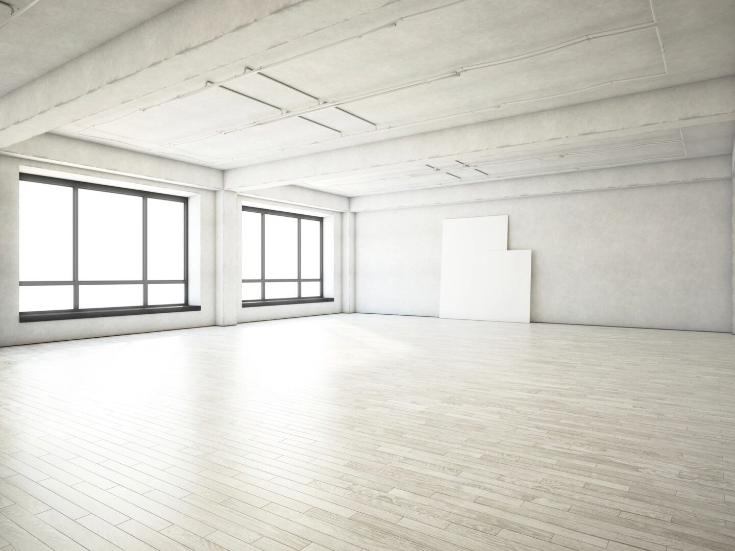 A large empty room with windows and wooden floors.