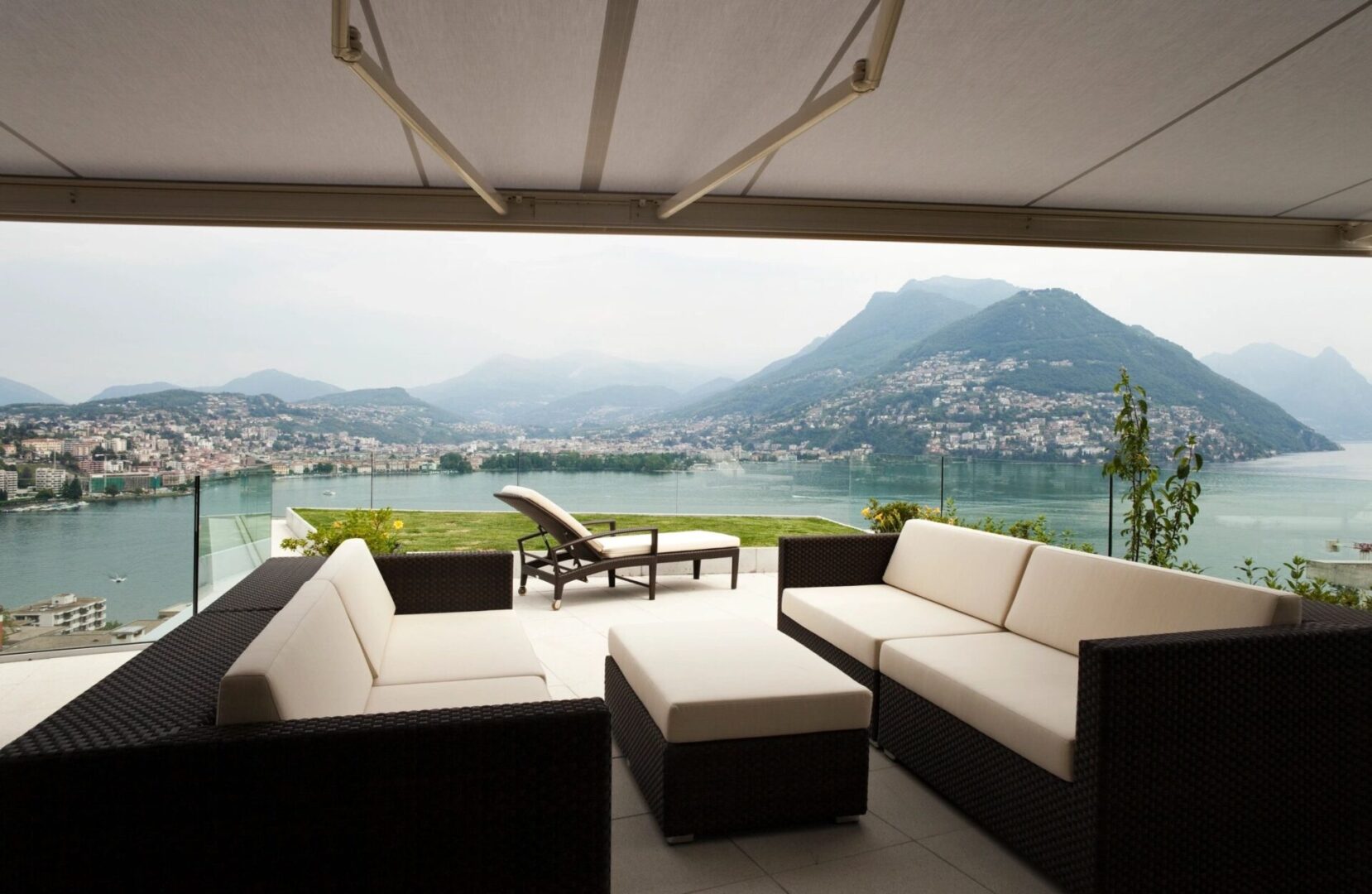 A patio with a view of the lake and mountains.